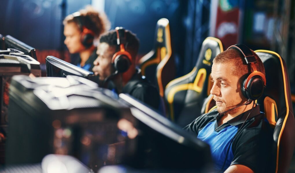 Male cybersport gamer wearing headphones playing online video games